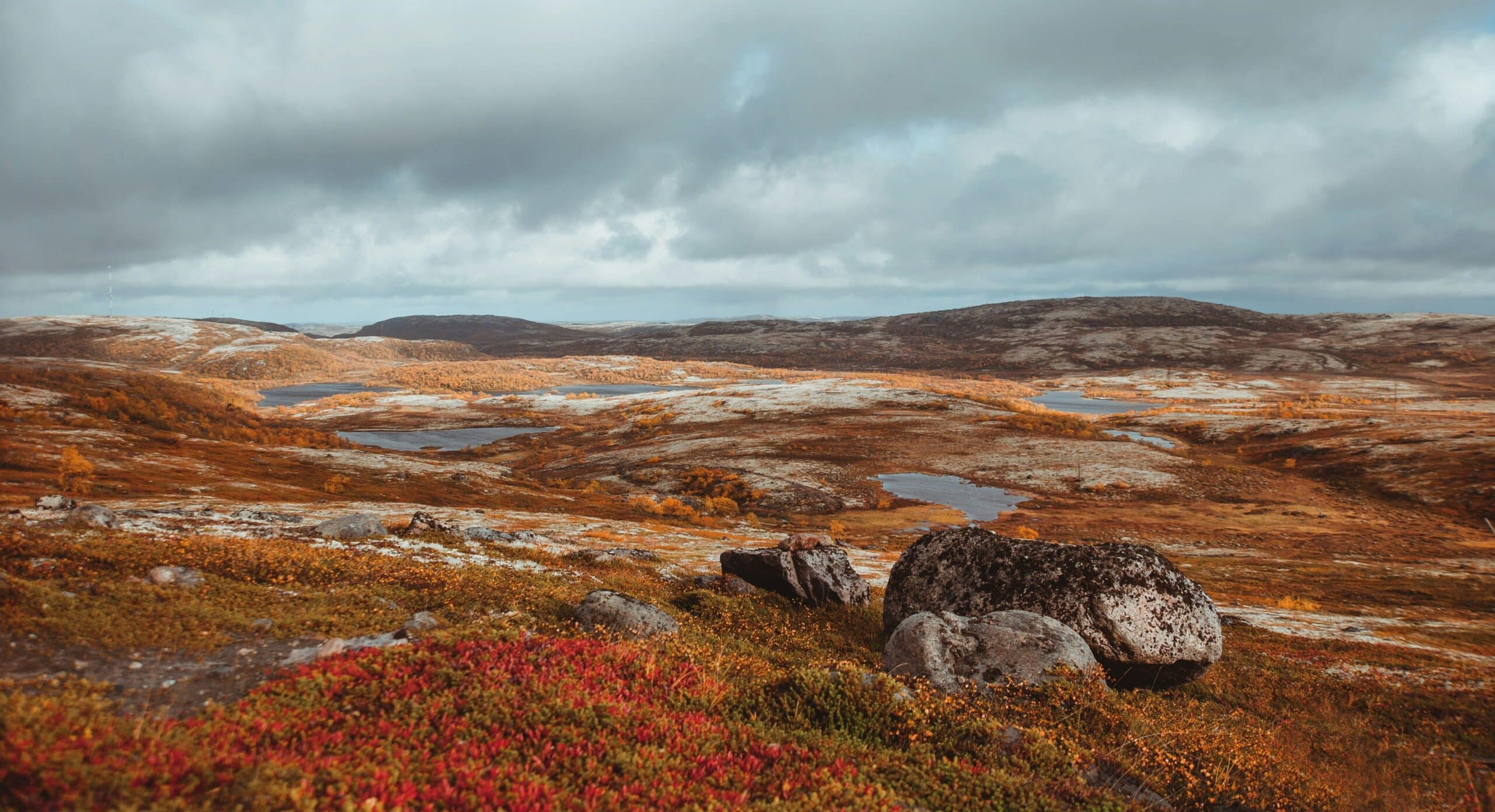 A colorful rocky landscape with a body of water in the distance