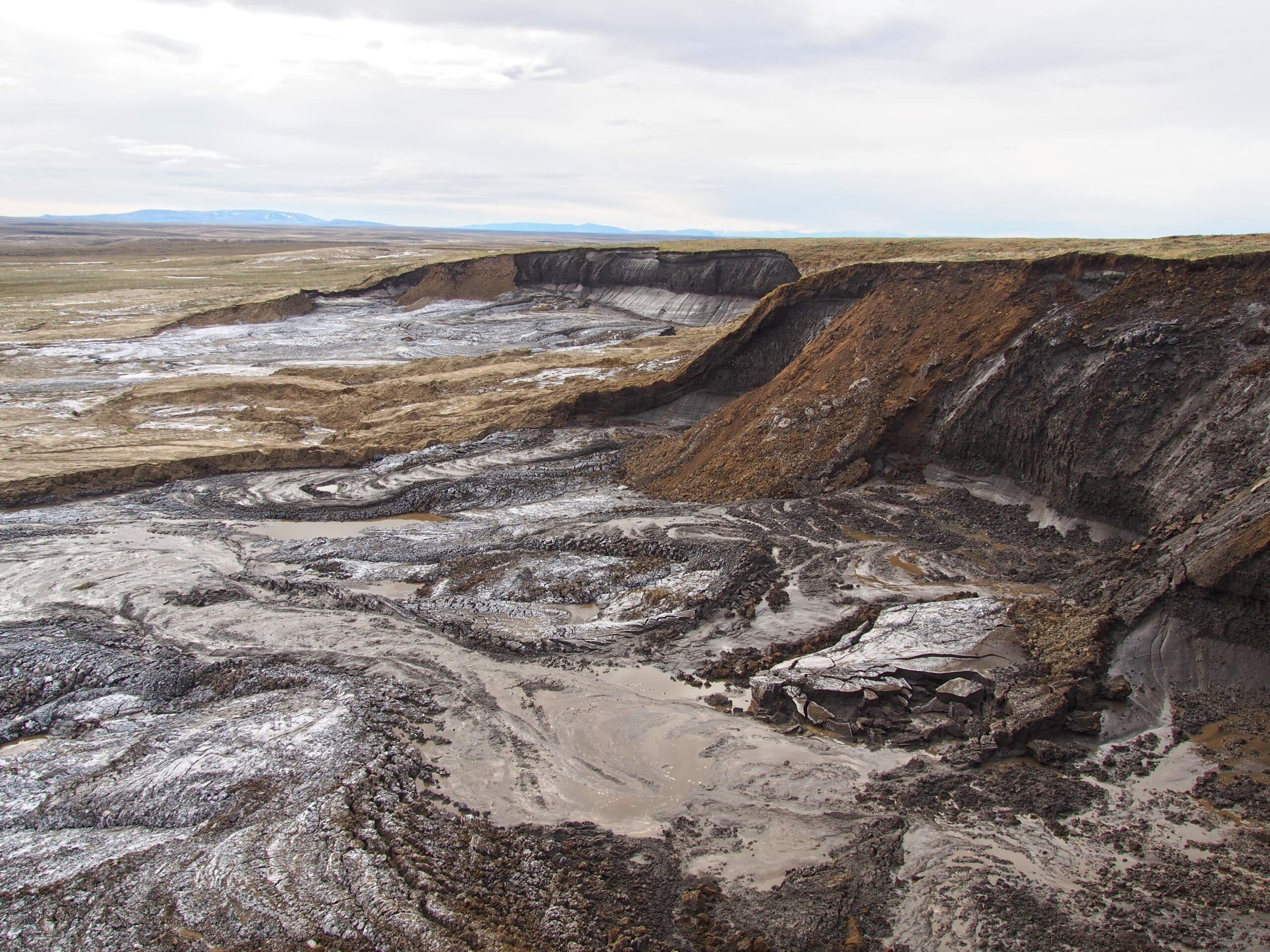 A cliff above a shallow valley with soil deposits following permafrost thawing